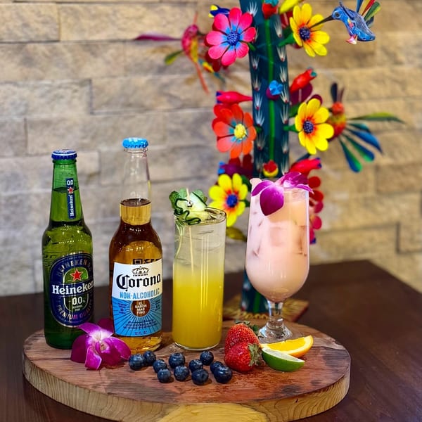 Mezcal Mexican Restaurant's non-alcoholic drinks, including Heineken 0.0, Corona, and two colorful cocktails with fruit.